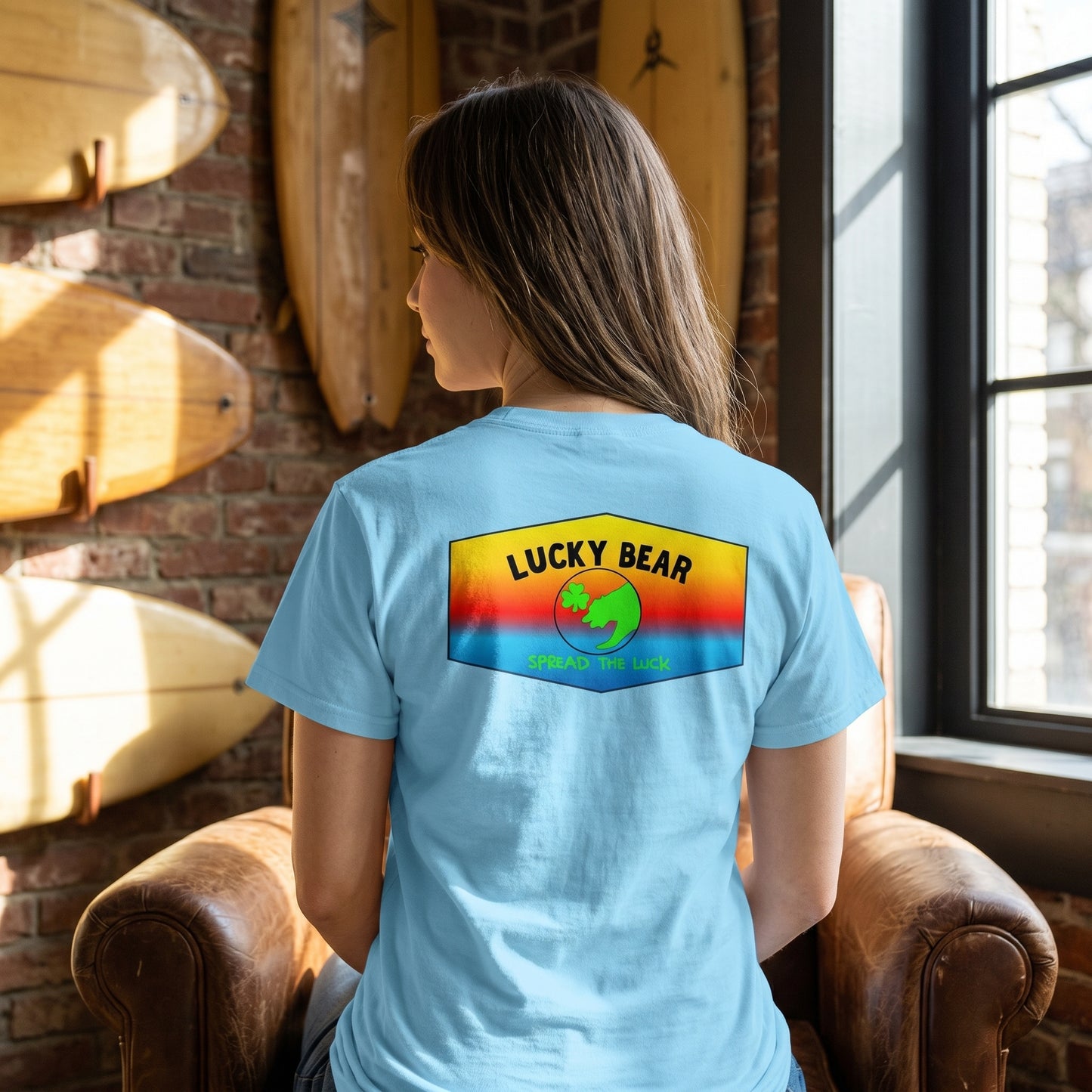 Model seated indoors wearing the Spread the Luck ombre sunset classic tee, with focus on fabric details and sunset design.
