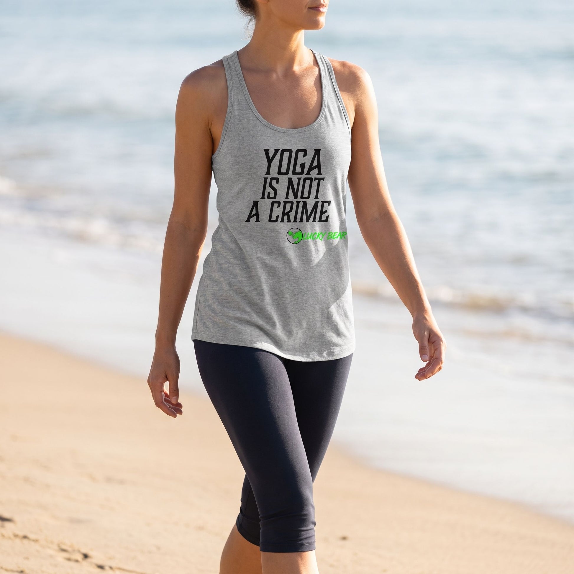 Relaxed woman walking along sunlit beach in casual yoga tank and capri pants, emphasizing breathable fabric, relaxed fit, and natural movement in a natural outdoor setting.
