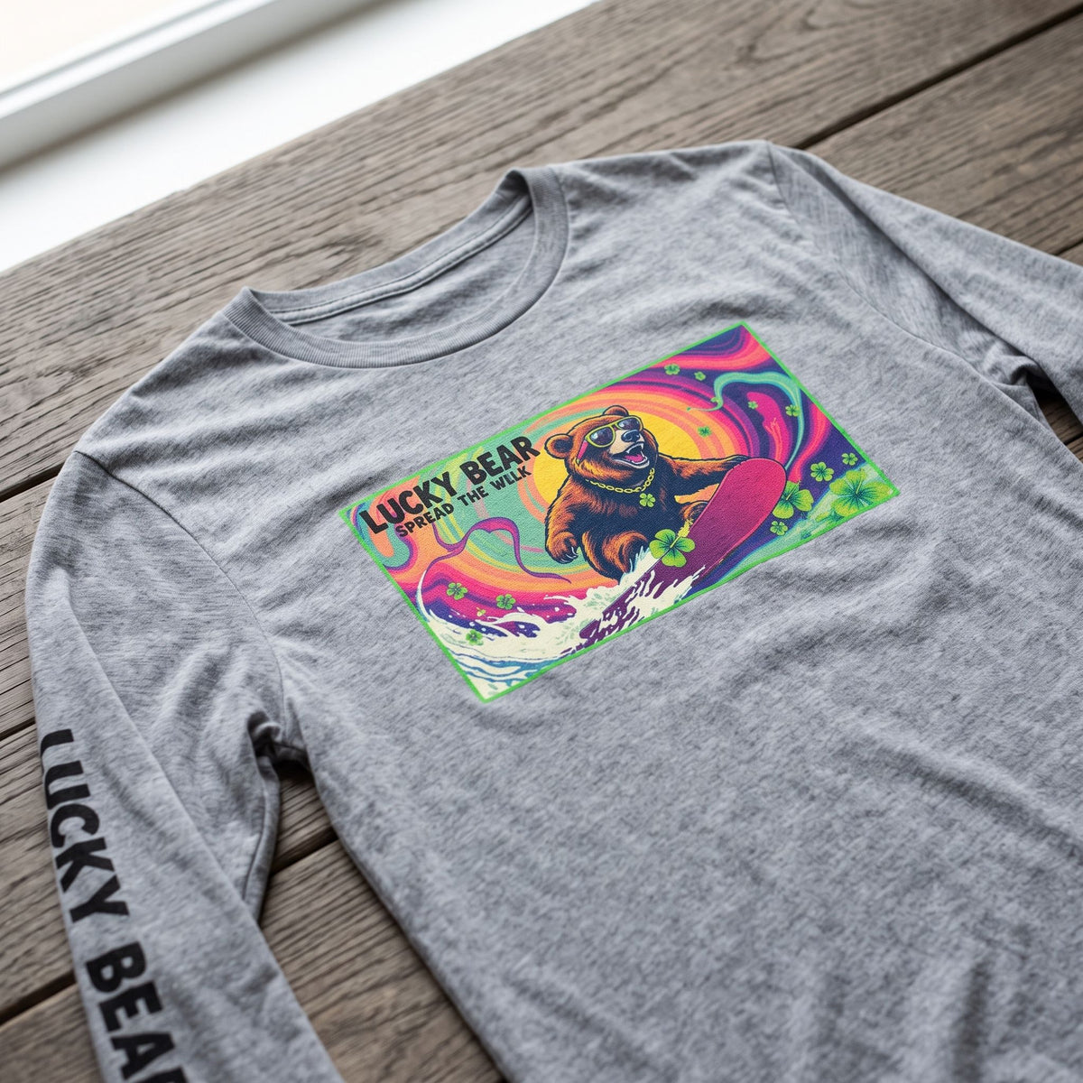 Close-up of the Sierra bear graphic print on a cotton long-sleeve shirt laid on a wooden surface.