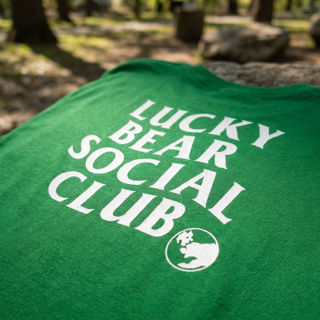 Close-up of white logo on Lucky Bear Social Club cotton T-shirt, highlighting fabric texture and logo details.
