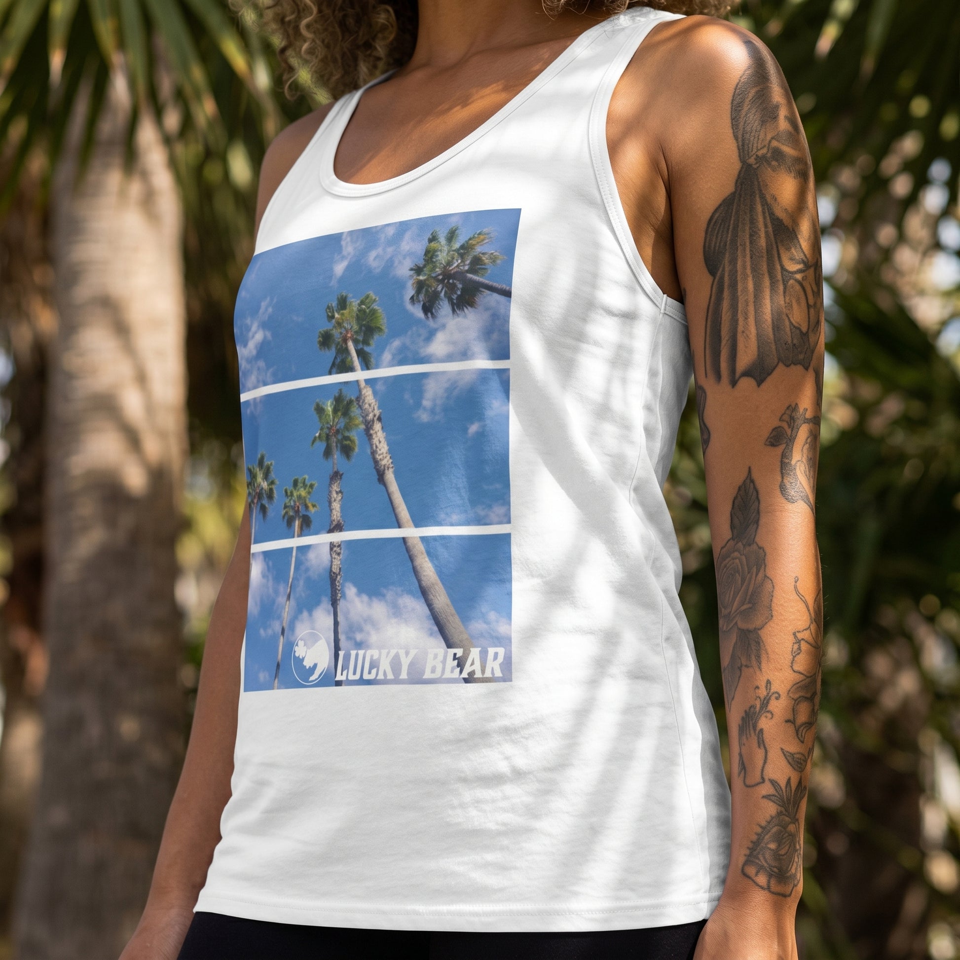 Close-up of Palm View Tank Top showing fabric texture and stitching, worn by a model with palm trees in the background.