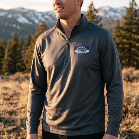 Close-up of Sierra Sunset quarter-zip pullover highlighting fabric texture and zipper details in a natural outdoor setting during golden hour.