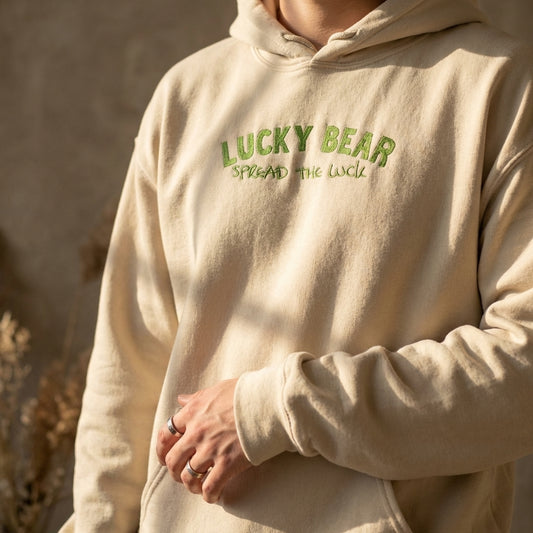 Close-up of the cozy 'Spread the Luck' hoodie highlighting fabric texture and stitching on a casually styled model with natural light.