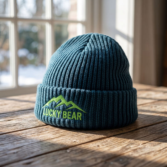 Close-up of Sierra Summit Fisherman beanie showing detailed ribbed knit texture, placed on a wooden surface with natural sunlight.