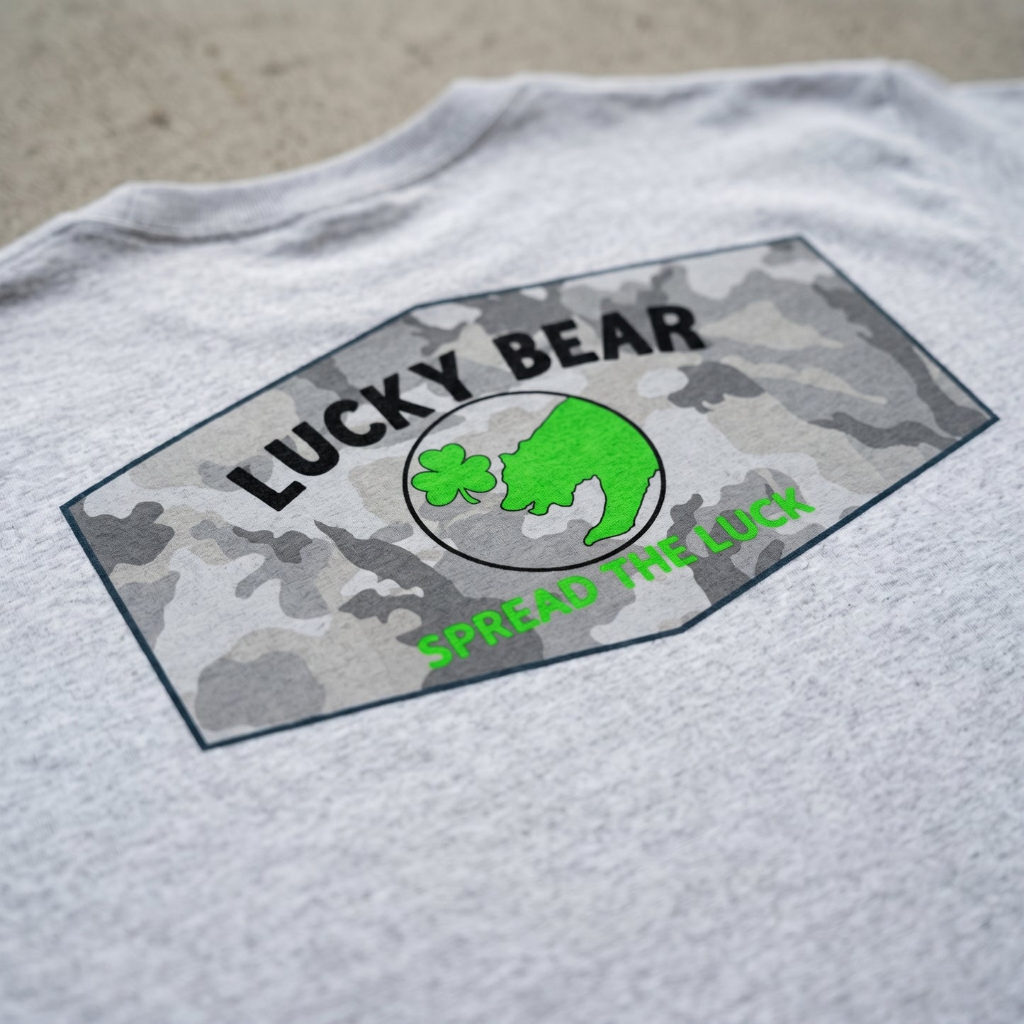 Close-up of Lucky Bear Snow Day Tee showing fabric texture and printed design with natural diffused light.