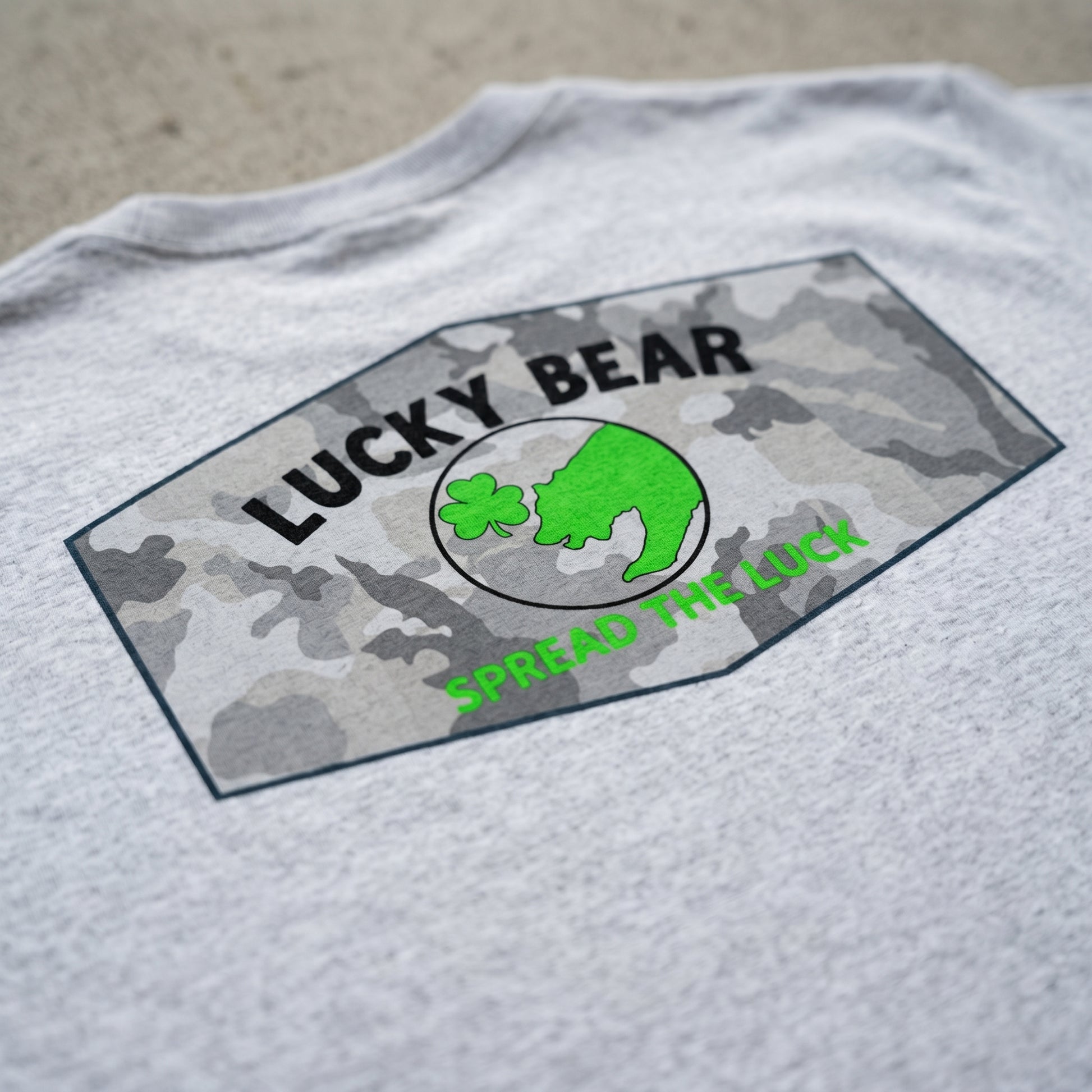 Close-up of Lucky Bear Snow Day Tee showing fabric texture and printed design with natural diffused light.