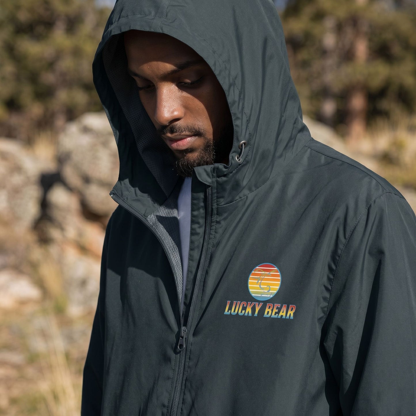Close-up of the windbreaker's upper section, showing reversed zipper tape, matte eyelets, and mesh hood lining details.
