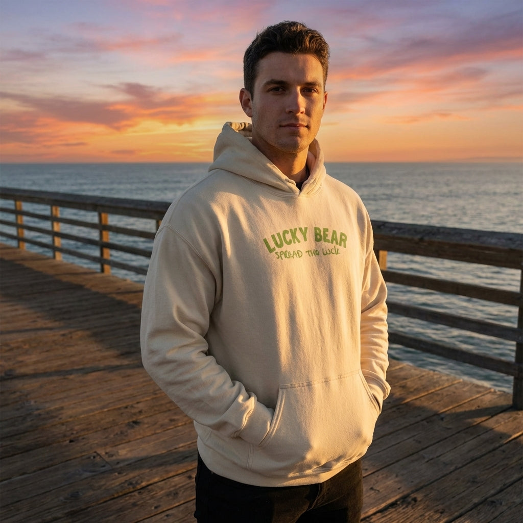 Model wearing the relaxed fit 'Spread the Luck' hoodie standing on a pier at sunset, showcasing its size and silhouette during golden hour.