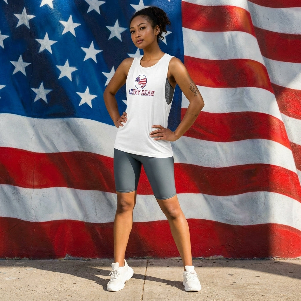 Woman wearing Ladies’ All American Luck Muscle Tank with American flag mural in relaxed outdoor setting.