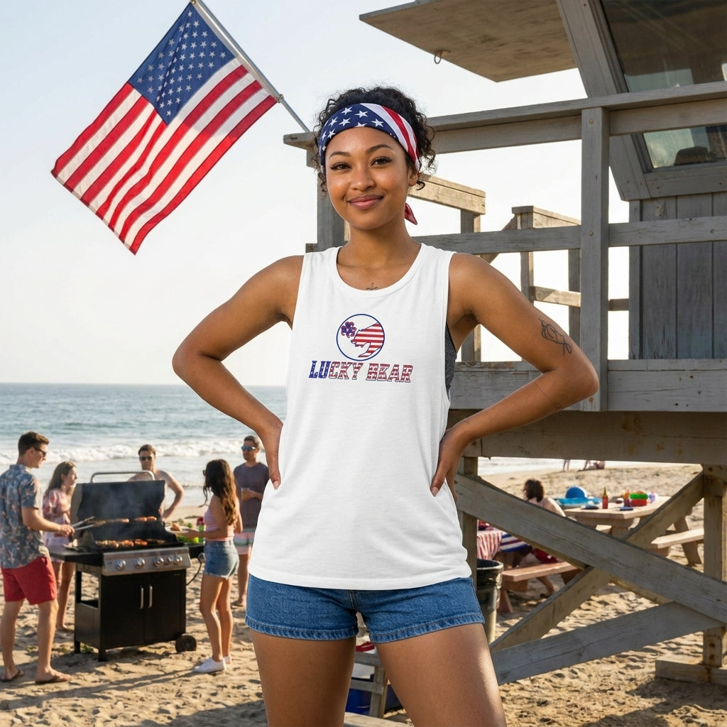 Woman in Ladies’ All American Luck Muscle Tank at beach BBQ with blue shorts and American flag accessories.