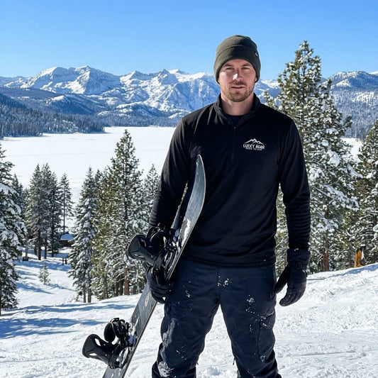 Snowboarder wearing a white lightweight quarter-zip pullover carving snow on Lake Tahoe slope during winter.