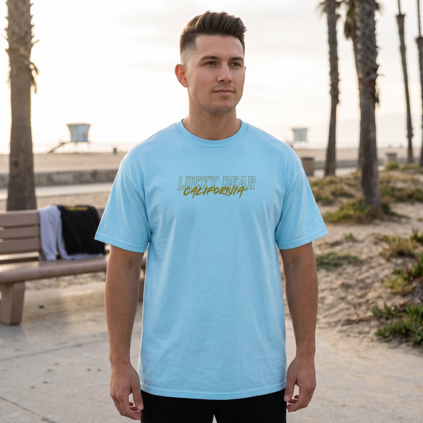 Full-body shot of male model in San Diego Sunset tee outdoors by the coast, showing fit and streetwear style.