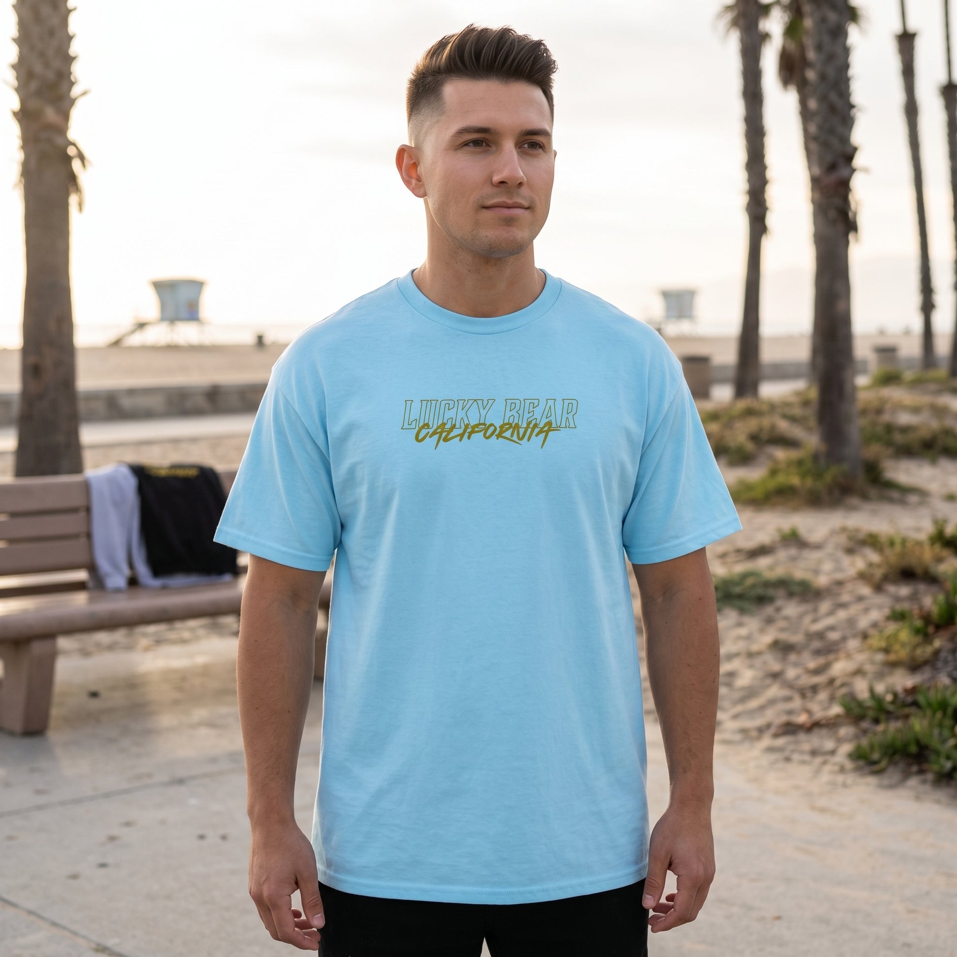 Full-body shot of male model in San Diego Sunset tee outdoors by the coast, showing fit and streetwear style.