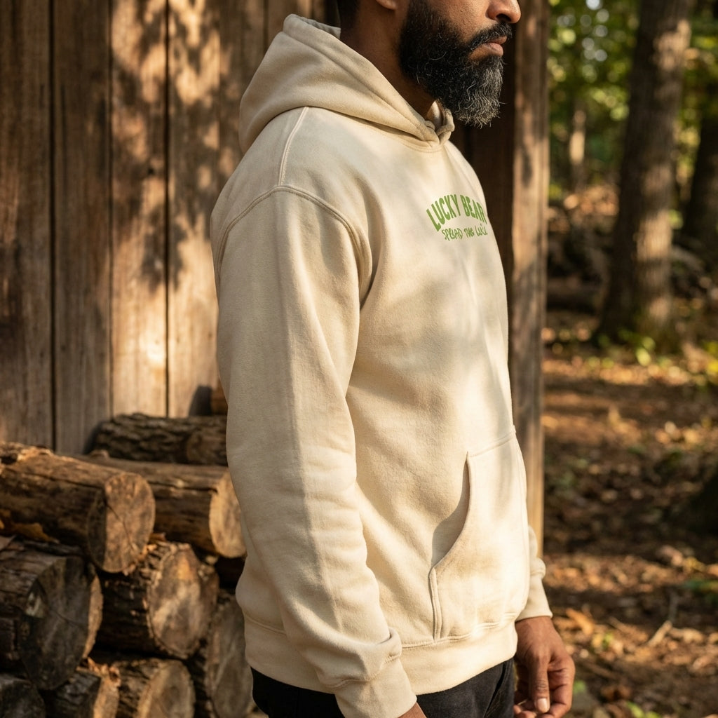 Side view of the hoodie highlighting detailed stitching and soft fabric in a rustic outdoor setting with wooden elements.