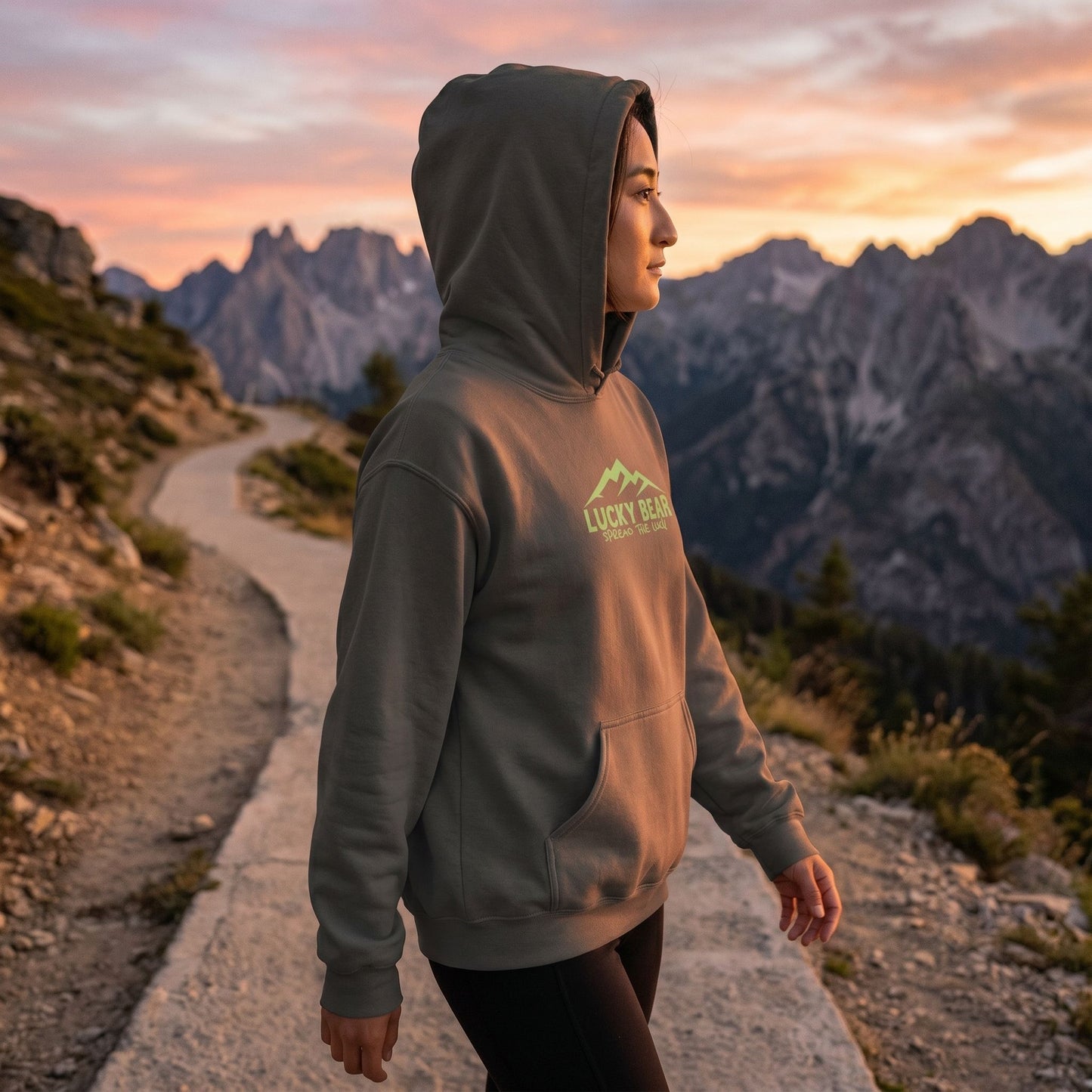 Model in Sierra Summit hoodie walking along mountain trail at sunset, illustrating outdoor comfort and relaxed fit.