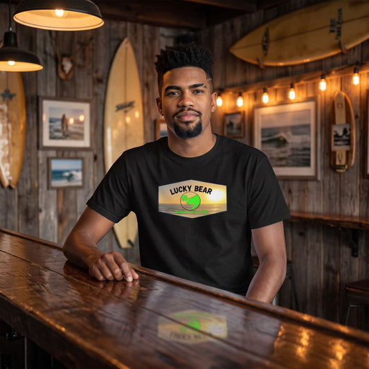 Model seated at a rustic surf-themed bar wearing the Spread the Luck Sunset classic tee, highlighted by warm ambient lighting and vintage decor.